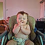 baby, high_chair, messy, food_smear, clapping, happy, indoor, person, woman, couch, phone, living_room, furniture, diaper, child, smile, seat_belt, home, casual, relaxed