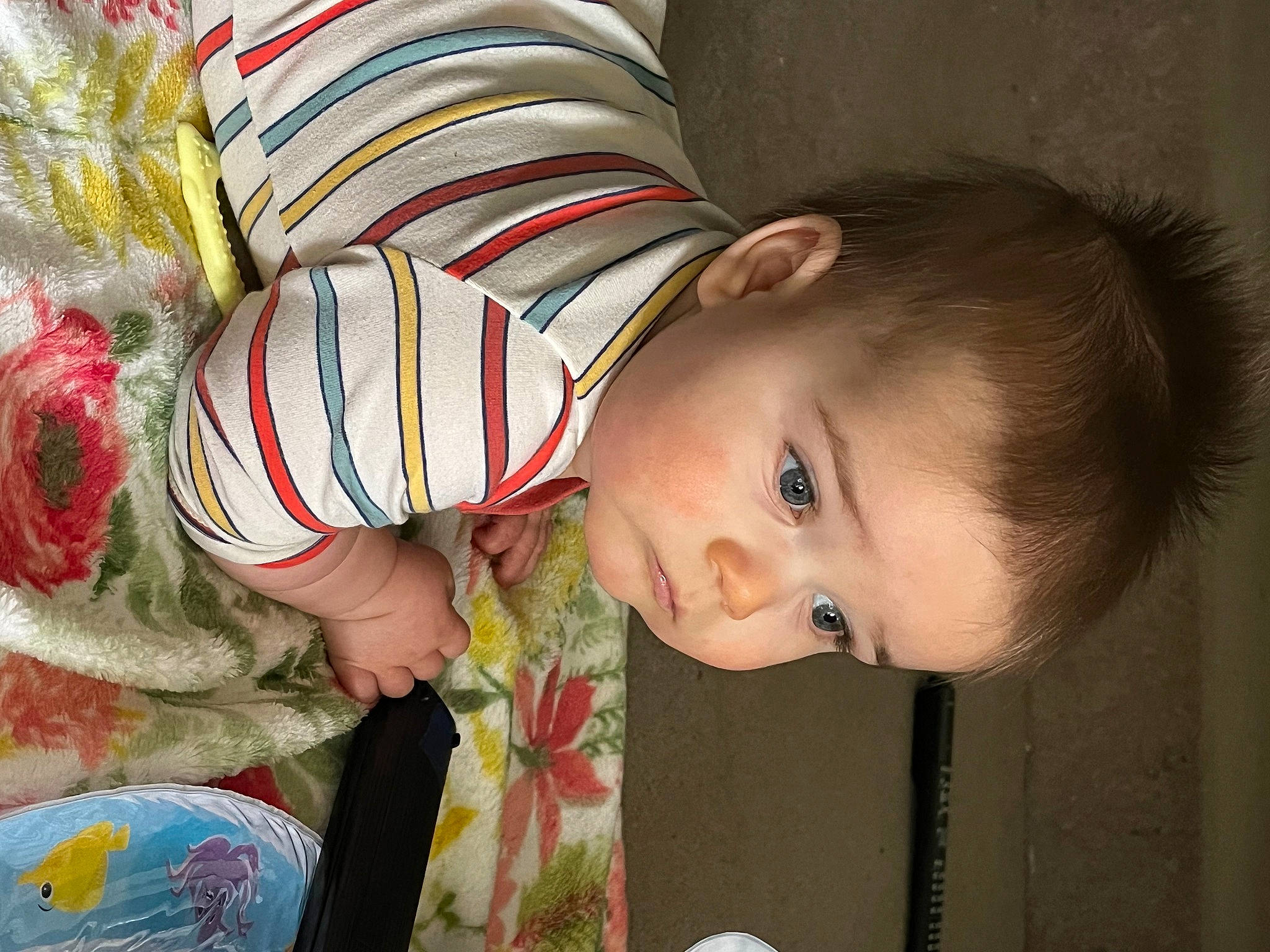 Milo is registered to the contest to win money with this photo: arm, baby, baby_products, baby_toddler_clothing, cheek, child, eye, facial_expression, fun, happy, head, human_body, iris, nose, pattern, person, room, skin, textile, toddler