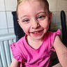 child, smiling, pink_shirt, portrait, face, happy, indoor, young_child, casual_clothing, blonde_hair, closeup, person, cute, sitting, table, radiator, background, light_skin, eyelashes, cheerful
