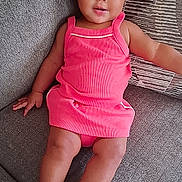 Wynter is registered to the contest to win money with this photo: baby, child, pink_dress, headband, bow, couch, gray_couch, sparkly_shoes, toddler, indoor, smiling, cute, portrait, person, sitting, happy, fashion, footwear, infant, comfortable