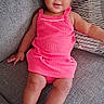 baby, child, pink_dress, headband, bow, couch, gray_couch, sparkly_shoes, toddler, indoor, smiling, cute, portrait, person, sitting, happy, fashion, footwear, infant, comfortable