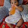 Wynter joined the competition — help win amazing prizes! baby, blanket, bottle, cartoon_faces, child, comfort, cozy, curly_hair, cushion, cute, dress, drink, fruit_pattern, indoor, person, playful, red, sitting, toddler, young_child