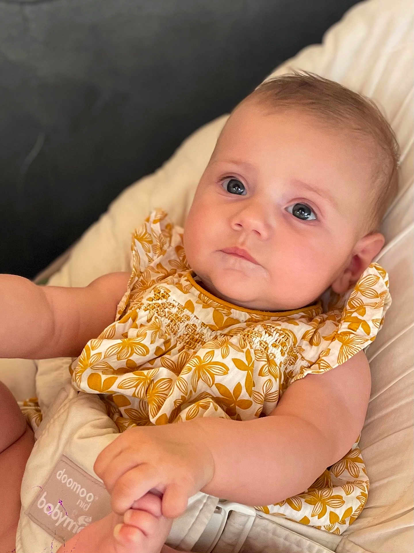 Salomé a rejoint le concours — aidez-le/la à gagner de superbes lots ! baby, infant, child, face, expression, clothing, dress, pattern, floral, yellow, white, seat, cushion, hand, skin, portrait, indoor, cute, young, comfort