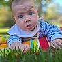 baby, infant, drool, blue_eyes, blanket, striped_clothing, outdoor, grass, bokeh, portrait, curious, child, young, face, skin, head, hand, nature, daylight, toddler