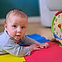 baby, infant, child, toy_clock, colorful, foam_mat, floor, playtime, indoor, curious, blue_eyes, gray_clothing, wooden_toy, early_learning, bright_colors, looking_at_camera, cute, young_child, home, portrait