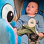 baby, child, blue_pajamas, stroller, plush_toy, toy, infant, seatbelt, indoor, curious, looking, face, hand, blanket, comfort, soft_toy, mamas_and_papas, baby_gesture, childcare, infant_clothing
