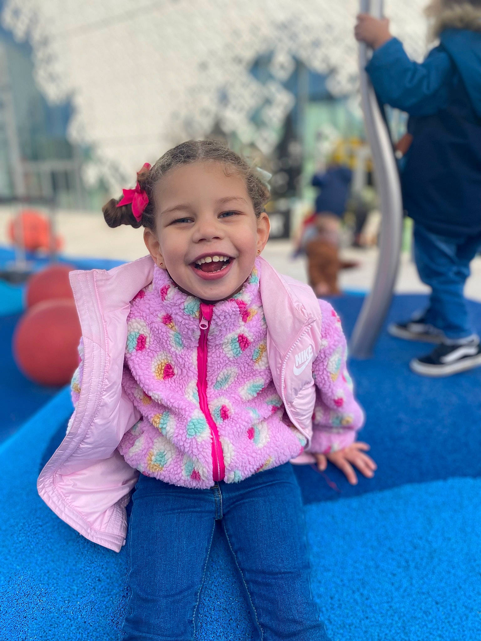 Mia participe au concours pour gagner de l'argent avec cette photo : blue, child, city, event, facial_expression, fun, grass, hairstyle, happy, head, jeans, joy, leisure, magenta, person, play, recreation, sitting, skin, smile