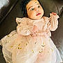 Vamika is registered to the contest to win money with this photo: blackhair, child, clothing, couch, dress, face, female, flower, formalwear, furniture, girl, hair, happy, head, person, photography, portrait, sitting, sleeve, smile