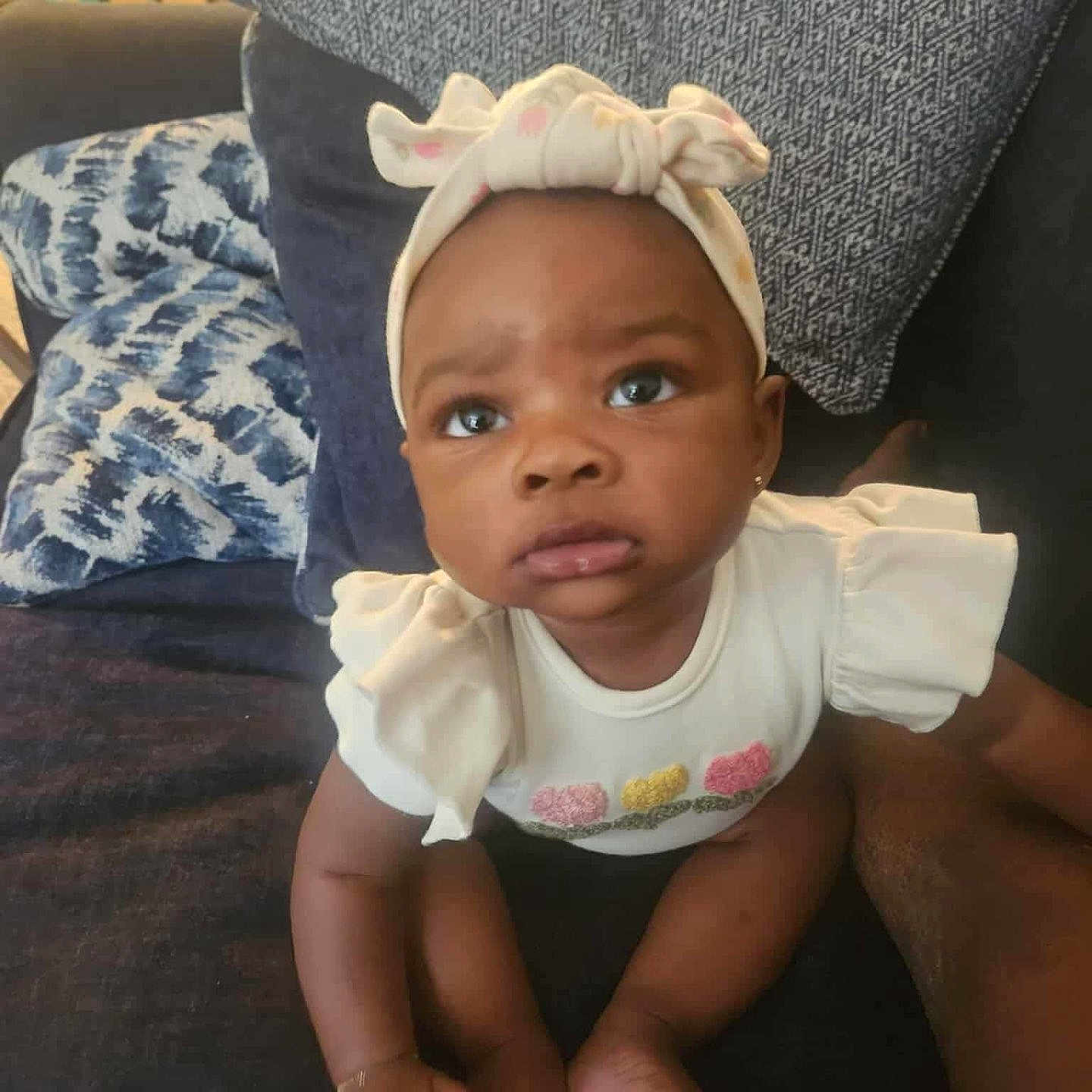 Zyla is registered to the contest to win money with this photo: baby, baseballcap, bonnet, cap, clothing, couch, cushion, face, furniture, hat, head, homedecor, pants, person, photography, pillow, portrait, shorts, sitting, t_shirt