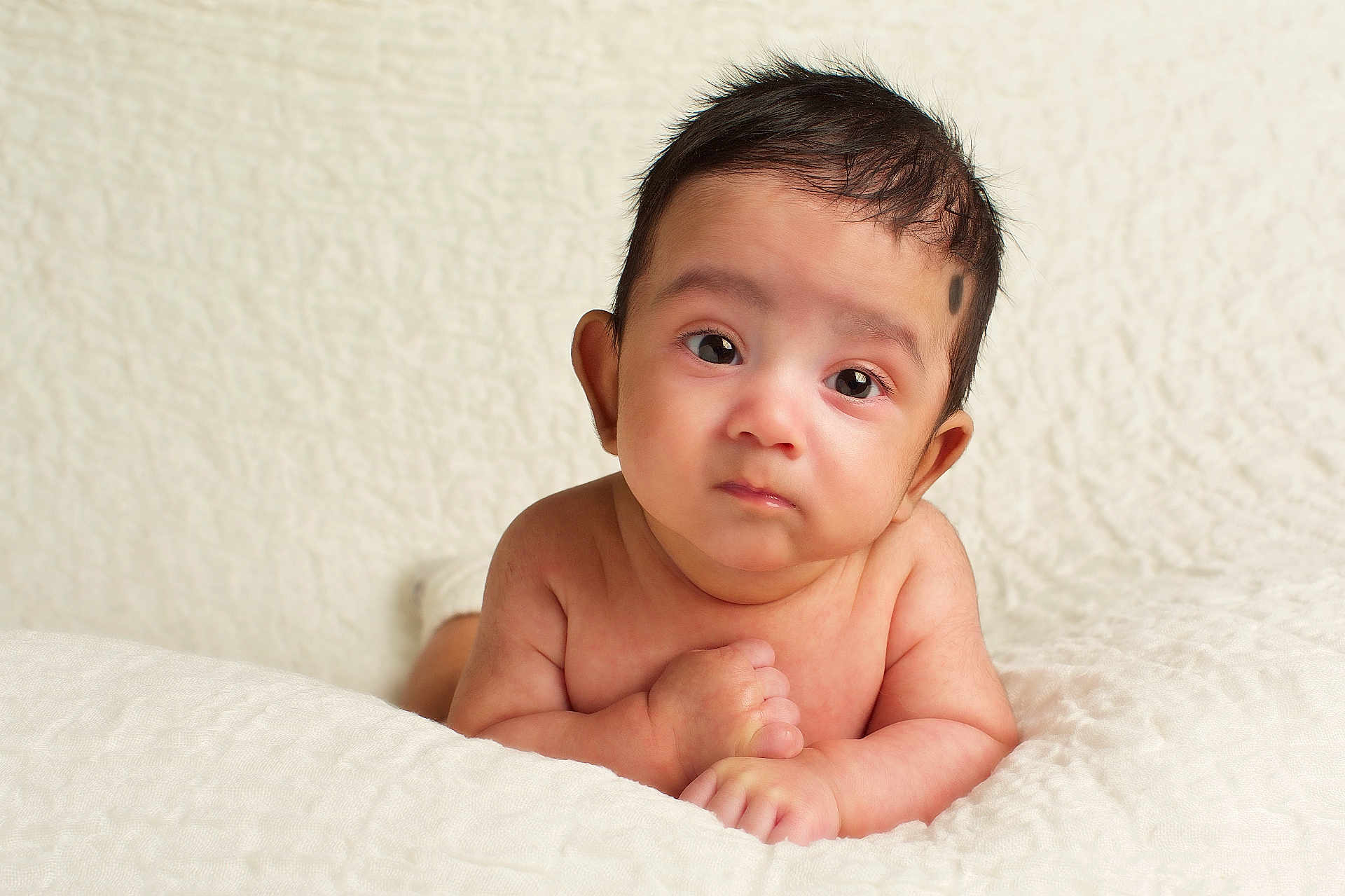 Vivian joined the competition — help win amazing prizes! baby, infant, child, portrait, face, skin, expression, cute, lying_down, blanket, soft_texture, indoors, newborn, hands, head, eyes, young, adorable, human, curious