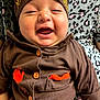 baby, infant, smiling, brown_clothing, hat, thanksgiving, orange, buttons, happy, person, cute, leopard_print, pattern, holding, child, portrait, indoors, closeup, celebration, festive