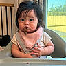 baby, child, high_chair, bib, food, indoor, curtains, window, hair_clip, messy, face, mouth, hands, table, seat, curious, skin, clothing, person, infant