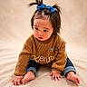 Kendall is registered to the contest to win money with this photo: toddler, child, baby, sitting, sweater, blue_bows, hair_ties, jeans, barefoot, soft_blanket, indoor, cute, curious, portrait, young_child, cozy, knitwear, hands, feet, expression