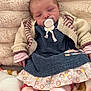baby, infant, pacifier, sleeping, knitted_cardigan, dress, floral, blanket, soft, cozy, cute, child, young, clothing, pink, striped_sleeves, comfort, portrait, indoors, resting