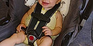 Lily joined the competition — help win amazing prizes! baby, child, smiling, yellow_headband, car_seat, safety_harness, infant, cute, happy, padded_seat, patterned_cushion, indoor, wooden_floor, clothing, person, headwear, baby_girl, seat_belt, closeup, portrait