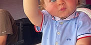 Jayden participe au concours pour gagner de l'argent avec cette photo : toddler, child, high_chair, food, biscuit, blue_eyes, polo_shirt, short_sleeves, indoor, person, curious, table, hand, face, light, background, adult, seated, expression, casual_clothing