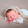 Jayden a rejoint le concours — aidez-le/la à gagner de superbes lots ! baby, newborn, sleeping, hat, knitted_hat, cozy, blanket, soft_texture, close_up, cute, infant, peaceful, resting, portrait, child, warm, hands, face, closed_eyes, toddler