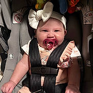 Yma Isabell is registered to the contest to win money with this photo: baby, car_seat, pacifier, headband, bow, child, infant, seatbelt, toy, smile, cute, pink_clothing, plush_toys, safety, straps, closeup, adorable, happy, indoor, young_child