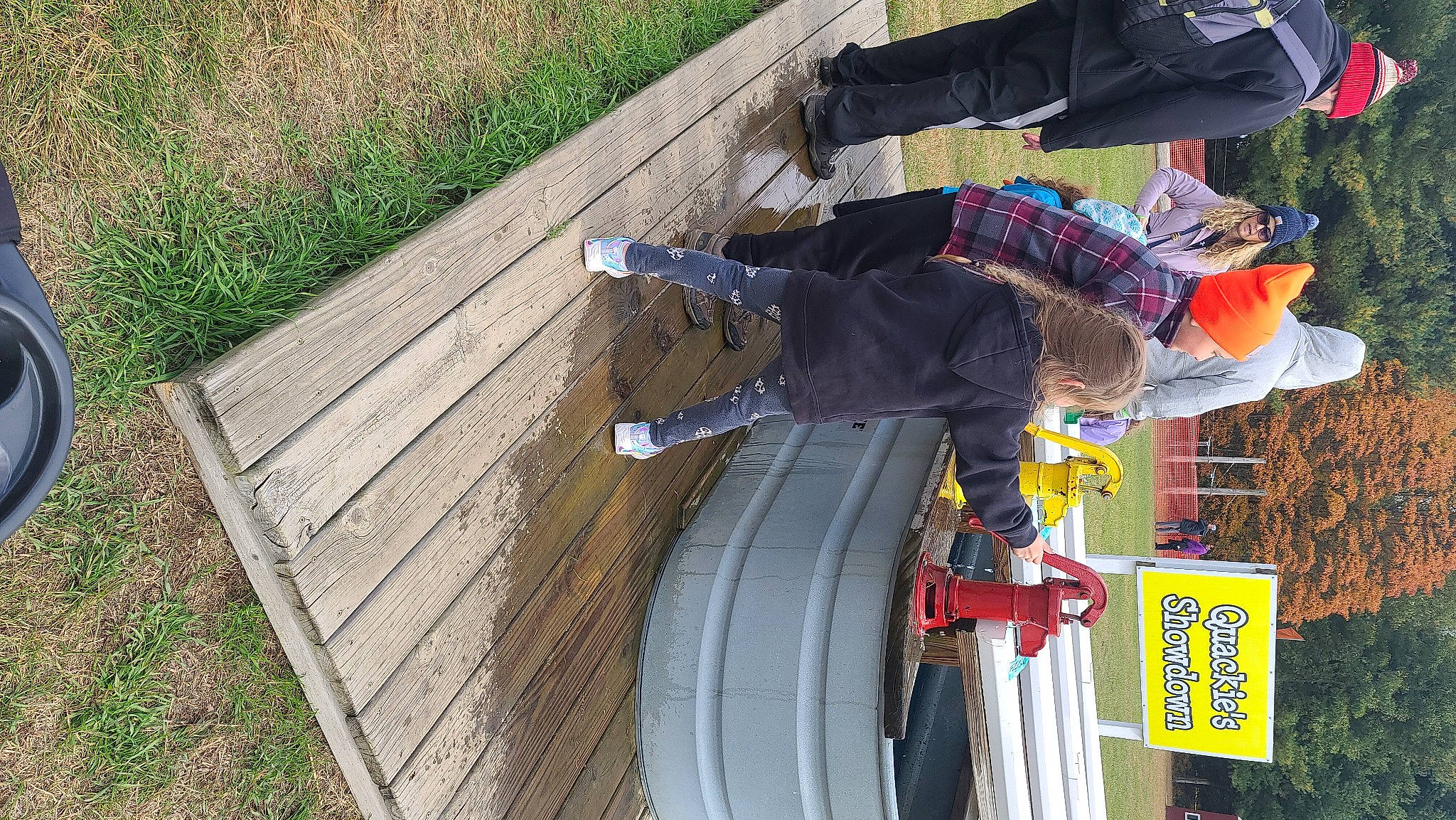 Carlee is registered to the contest to win money with this photo: fun, grass, hardwood, headwear, leisure, outdoor_furniture, outdoor_shoe, person, plant, pole, recreation, tree, walking_shoe, wood