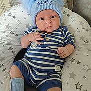 Marky is registered to the contest to win money with this photo: baby, infant, hat, pom_poms, blue_hat, striped_clothing, peter_rabbit, socks, white_shoes, cushion, star_pattern, plush_cushion, seated, indoors, cute, child, portrait, baby_clothes, knitwear, soft_furniture