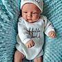 baby, infant, white_clothing, knitwear, hat, blue_blanket, texture, cute, newborn, face, skin, person, portrait, cozy, resting, hands, expression, indoor, soft, comfortable
