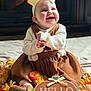 Riley joined the competition — help win amazing prizes! autumn, baby, blanket, bow, child, cozy, cute, decorations, dress, fall, fireplace, flowers, happy, indoors, portrait, pumpkin, seasonal, sitting, smiling, sweater