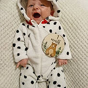 Jules a rejoint le concours — aidez-le/la à gagner de superbes lots ! baby, infant, one_month, milestone_marker, polka_dot_onesie, hooded_romper, white_blanket, smiling, open_mouth, face, hand, feet, cozy, portrait, newborn, plush_texture, spot_pattern, baby_photography, card_sign, cute