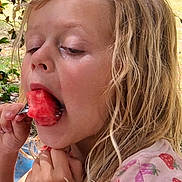 Harlem joined the competition — help win amazing prizes! child, girl, watermelon, eating, fruit, outdoor, summer, blonde_hair, strawberry_shirt, nature, greenery, table, casual_clothing, happy, closeup, food, snack, sunlight, portrait, young