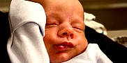 John is registered to the contest to win money with this photo: baby, sleeping, infant, face, skin, hand, clothing, white, peaceful, cute, portrait, newborn, soft, resting, closeup, young, relaxed, indoors, child, person