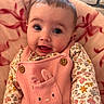 baby, infant, face, expression, pink_overall, bunny_design, floral_shirt, blanket, cozy, indoor, brick_wall, cute, child, portrait, smile, wide_eyes, young_child, person, apparel, soft_texture
