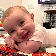 Lillith joined the competition — help win amazing prizes! baby, smiling, infant, quilt, colorful, indoor, happy, face, child, crawling, cheeks, eyes, clothing, toy, floor, brick_wall, table, person, head, cute