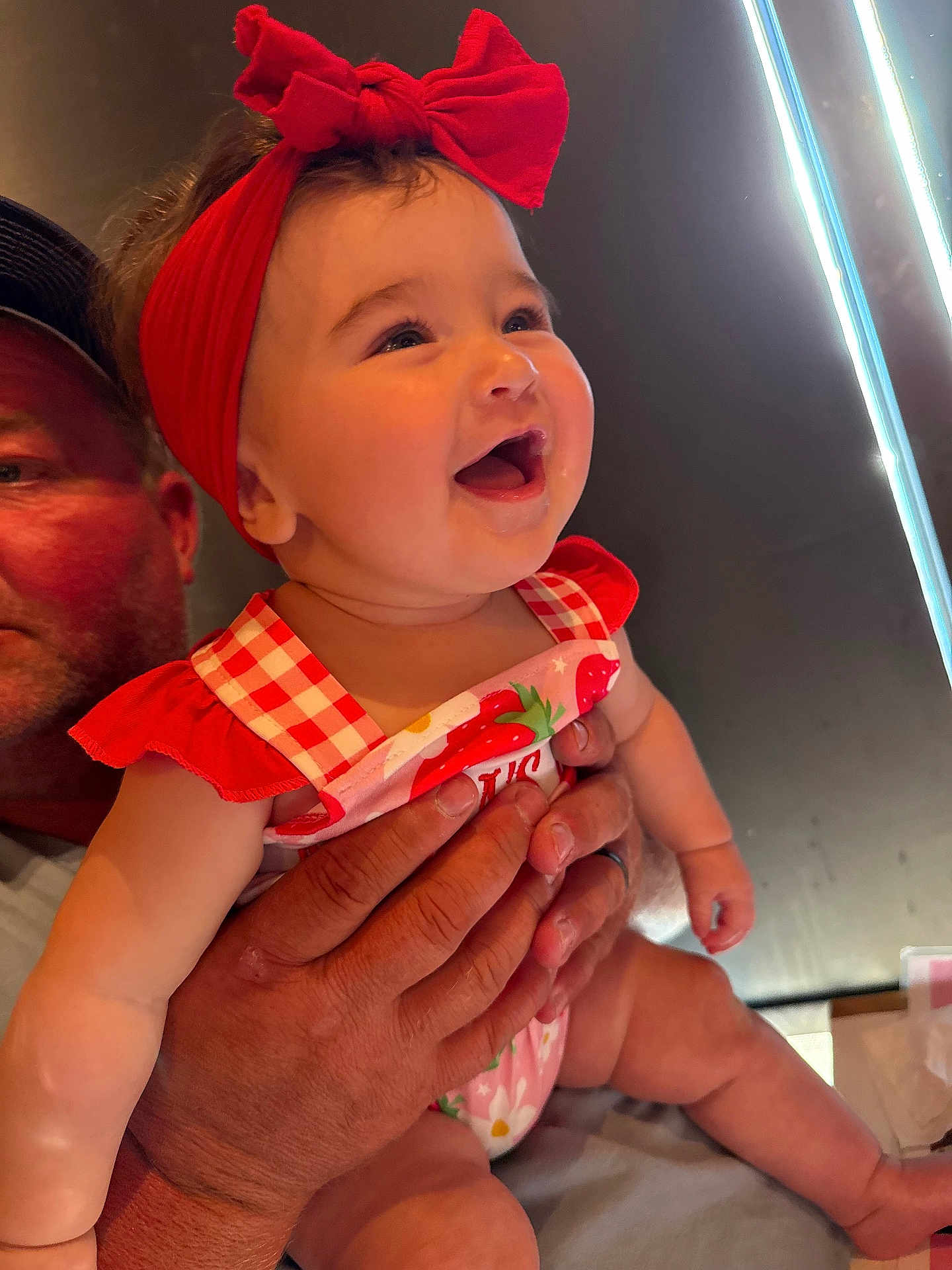 Avery joined the competition — help win amazing prizes! baby, child, smiling, red_bow, headband, strawberry, outfit, adult_hand, holding, happy, cute, infant, portrait, indoors, light, skin, person, expression, cheerful, face