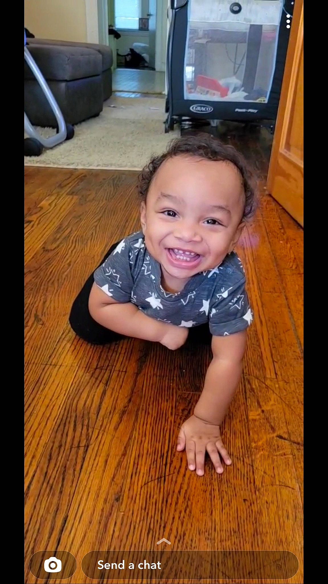 Josiah is registered to the contest to win money with this photo: baby_toddler_clothing, cable_television, flash_photography, floor, flooring, fun, happy, hardwood, home_appliance, iris, joy, laminate_flooring, nose, person, smile, television, television_set, thumb, toddler, varnish