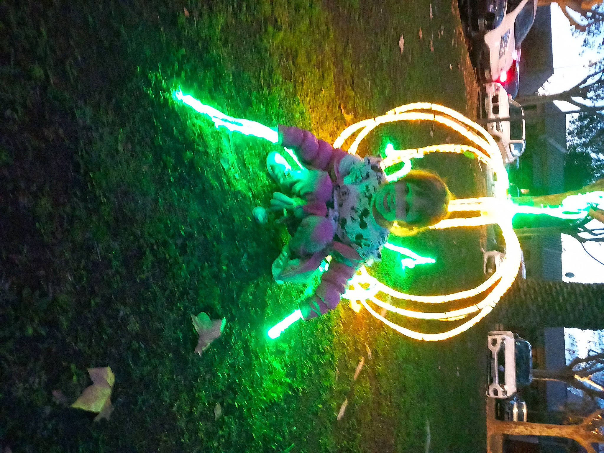 Ambre participe au concours pour gagner de l'argent avec cette photo : automotive_lighting, circle, darkness, electricity, entertainment, event, fictional_character, fun, graphic_design, graphics, grass, headlamp, joy, light, machine, neon, night, performing_arts, person, recreation