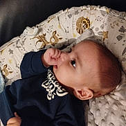 Chahine a rejoint le concours — aidez-le/la à gagner de superbes lots ! baby, infant, thumb_sucking, cushion, blanket, face, clothing, pattern, indoor, child, person, head, skin, sleeping_area, comfort, cute, young_child, cozy, portrait, resting