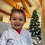 Erynn a rejoint le concours — aidez-le/la à gagner de superbes lots ! child, christmas_tree, clothing, couch, cozy, curtain, face, happy, holiday, home_decor, hoodie, indoor, living_room, ornaments, person, pigtails, portrait, smile, toddler, wooden_beams