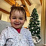 Erynn participe au concours pour gagner de l'argent avec cette photo : casual, child, christmas_tree, couch, cozy, curtains, decorations, face, festive, happy, holiday, home, indoor, person, pigtails, portrait, smiling, toddler, white_hoodie, wooden_beams