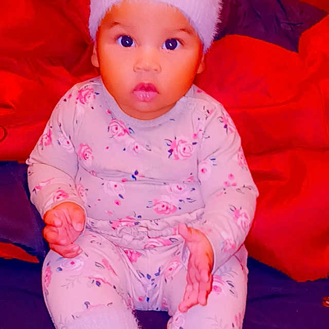 Geonna is registered to the contest to win money with this photo: baby, baby_toddler_clothing, cap, cheek, child, comfort, fun, happy, head, headgear, human_body, magenta, orange, peach, pink, red, sitting, skin, sleeve, toddler