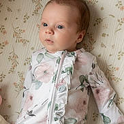 Shiloh is registered to the contest to win money with this photo: baby, infant, child, onesie, floral_pattern, blanket, lying_down, cute, portrait, face, eyes, soft_lighting, sleepwear, newborn, person, skin, head, expression, indoors, peaceful