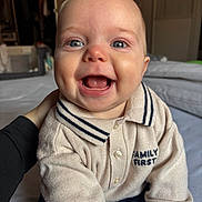 Tommy participe au concours pour gagner de l'argent avec cette photo : baby, smiling, face, blue_eyes, sweater, knitwear, family_first, hand, person, child, indoors, bed, bedroom, happy, cute, portrait, closeup, infant, warm_clothing, cheeks