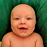 baby, smiling, face, child, infant, skin, happy, portrait, closeup, cute, green_background, eyes, cheeks, bare_shoulders, young, expression, human, head, newborn, funny