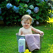Olivia joined the competition — help win amazing prizes! baby, baby_powder, child, cute, flowers, funny_face, grass, greenery, hydrangea, metal_tub, nature, outdoor, pink_towel, playful, rubber_duck, scrunched_face, summer, towel, tub, yellow_duck