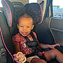 toddler, child, car_seat, curly_hair, smiling, pacifier, seatbelt, car_interior, sunlight, happy, cute, safety, portrait, young_child, black_hair, clothing, window, daylight, person, seat