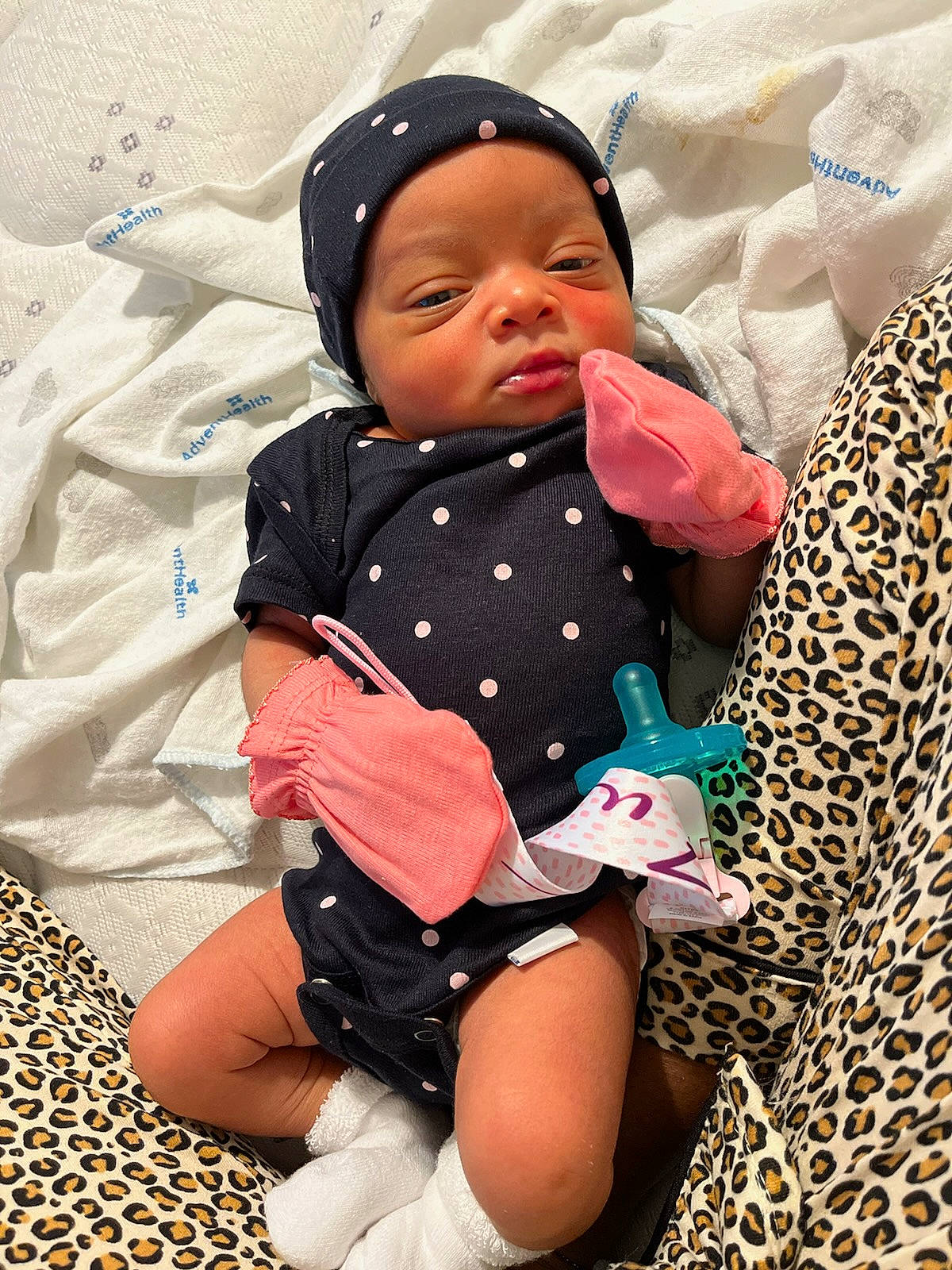 Zuri is registered to the contest to win money with this photo: baby, baby_toddler_clothing, child, comfort, eye, face, happy, head, headwear, human_body, lap, linens, outerwear, pattern, people_in_nature, person, skin, sleeve, sock, textile