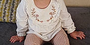 Victoria joined the competition — help win amazing prizes! toddler, child, girl, bow, pink_bow, white_top, floral_embroidery, patterned_pants, barefoot, couch, gray_couch, indoor, portrait, sitting, curious, wide_eyes, hands, feet, face, hair
