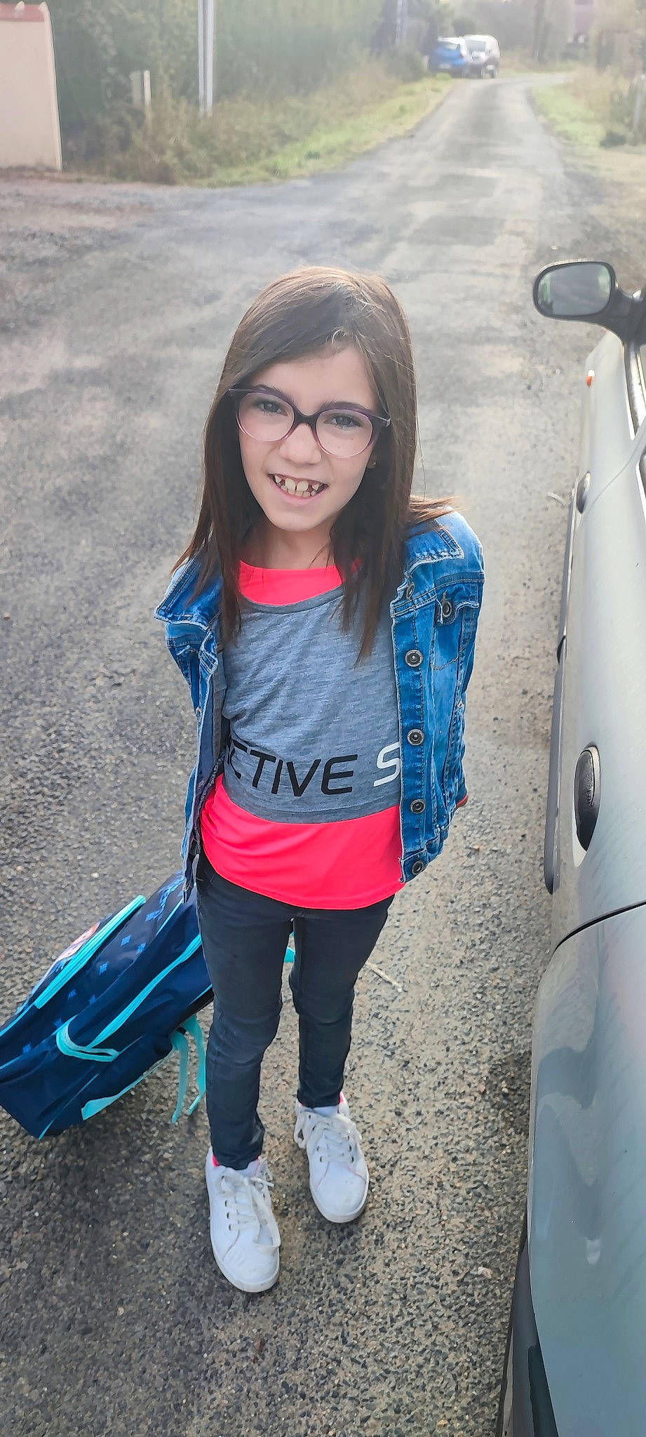 Emma a rejoint le concours — aidez-le/la à gagner de superbes lots ! automotive_tire, azure, cool, electric_blue, eyewear, fun, glasses, hairstyle, happy, joy, leisure, people, person, photograph, sleeve, smile, standing, t_shirt, travel, vehicle_door