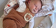 Noah a rejoint le concours — aidez-le/la à gagner de superbes lots ! baby, sleeping, infant, blanket, plush_toy, octopus, crib, clothing, overalls, lion_patch, sock, soft_texture, cute, resting, child, indoors, cozy, peaceful, nursery, toddler
