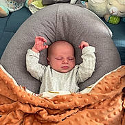 Noah participe au concours pour gagner de l'argent avec cette photo : baby, sleeping, blanket, pillow, plush_toy, nursery, infant, cozy, soft_texture, dinosaur_design, child, cute, comfort, cushion, rest, peaceful, indoors, person, warm, sleep