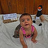 Kya joined the competition — help win amazing prizes! baby, infant, crawling, pink_overalls, stuffed_animal, duck, egg_carton, wooden_fence, white_blanket, sign, six_months, half_dozen, child, cute, smiling, indoors, portrait, young_child, toy, playful