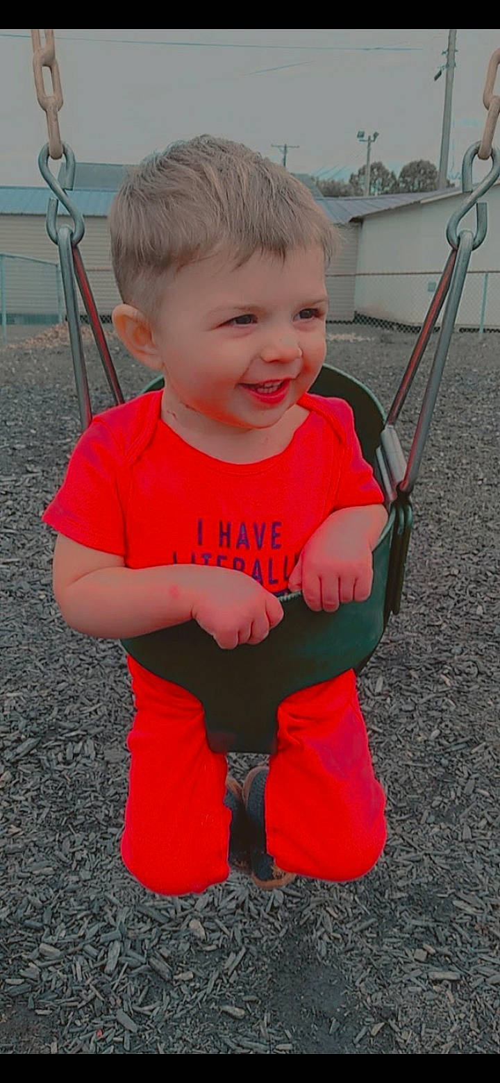 Jordan is registered to the contest to win money with this photo: baby, baby_toddler_clothing, chair, child, face, facial_expression, finger, fun, grass, hand, happy, human_body, leg, leisure, person, skin, sleeve, smile, standing, t_shirt